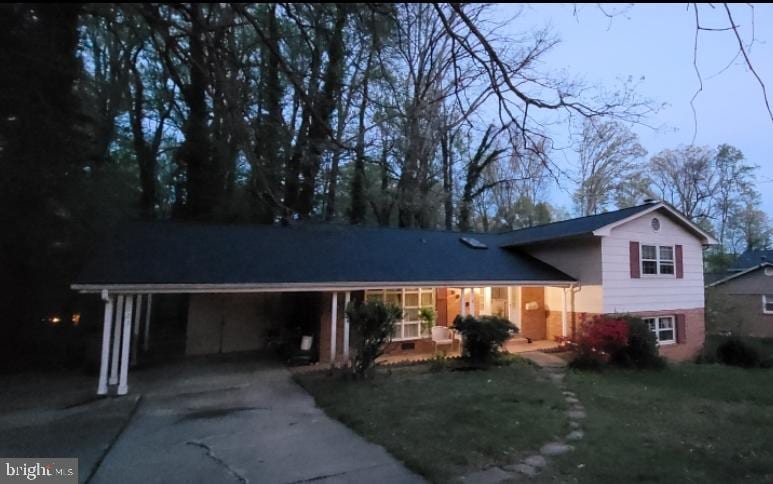 5023 Dodson Dr, Annandale, VA 22003 - tri-level home with concrete driveway, a carport, a porch, and a front yard