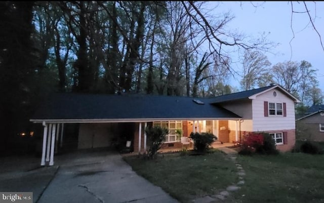 5023 Dodson Dr, Annandale, VA 22003 - tri-level home with concrete driveway, a carport, a porch, and a front yard
