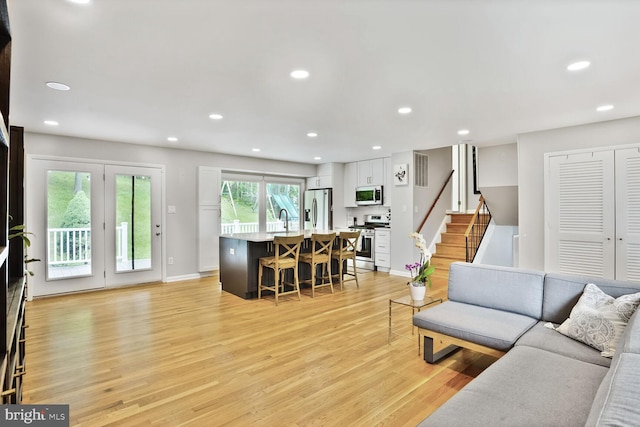 11106 Byrd Dr, Fairfax, VA 22030 - living room with light wood finished floors, stairs, recessed lighting, and baseboards