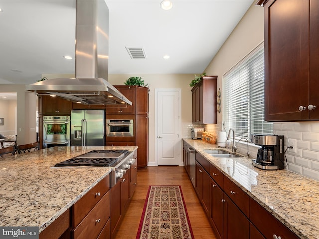 130 Grosbeak Ct, Lake Frederick, VA 22630 - kitchen featuring stainless steel appliances, island range hood, a sink, wood finished floors, and tasteful backsplash
