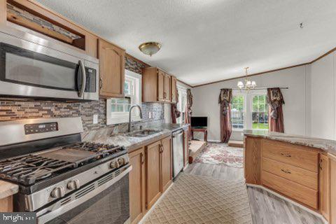 129 Trailway Rd, Middle River, MD 21220 - kitchen with appliances with stainless steel finishes, a sink, lofted ceiling, backsplash, and light wood-style floors