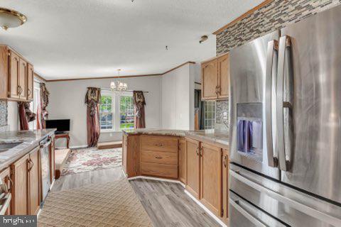 129 Trailway Rd, Middle River, MD 21220 - kitchen with stainless steel fridge, a peninsula, a chandelier, light countertops, and light wood-style flooring
