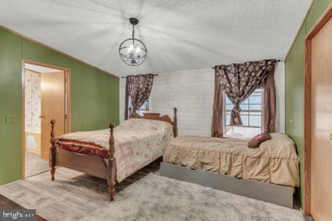 129 Trailway Rd, Middle River, MD 21220 - bedroom with a textured ceiling, a chandelier, and lofted ceiling
