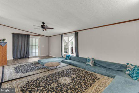 129 Trailway Rd, Middle River, MD 21220 - living room with lofted ceiling, ceiling fan, crown molding, a textured ceiling, and baseboards