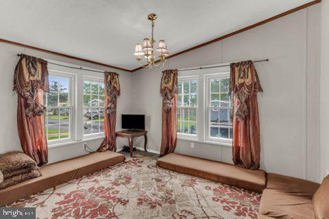 129 Trailway Rd, Middle River, MD 21220 - carpeted living area featuring plenty of natural light, lofted ceiling, a chandelier, and ornamental molding