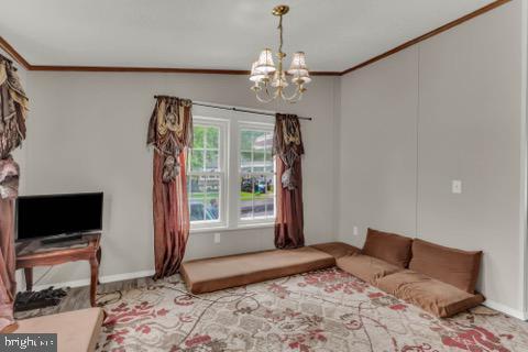 129 Trailway Rd, Middle River, MD 21220 - living room with crown molding, a chandelier, and baseboards