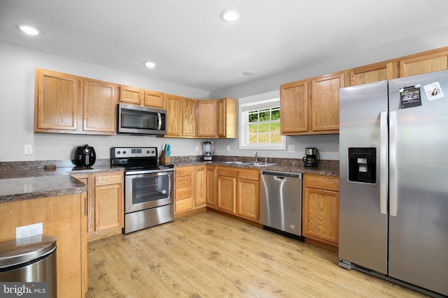 94 Gary Ln, Front Royal, VA 22630 - kitchen featuring appliances with stainless steel finishes, a sink, light wood-style flooring, recessed lighting, and dark stone counters