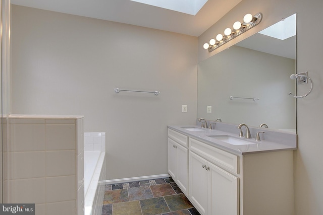 242 Tilden Way Unit 7242, Edgewater, MD 21037 - bathroom with a skylight, double vanity, a bath, and stone finish flooring
