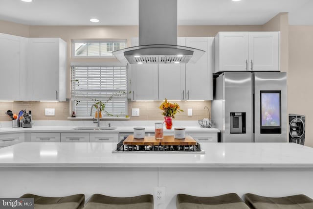 12116 Elmwood Dr, Brandywine, MD 20613 - kitchen featuring stainless steel fridge, island range hood, a sink, black stovetop, and a breakfast bar