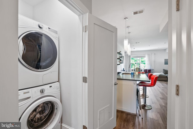 2221 M St NE Unit Ph1, Washington, DC 20002 - laundry room featuring stacked washing machine and dryer and wood finished floors
