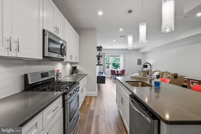 2221 M St NE Unit Ph1, Washington, DC 20002 - kitchen featuring appliances with stainless steel finishes, a sink, open floor plan, wood finished floors, and dark countertops