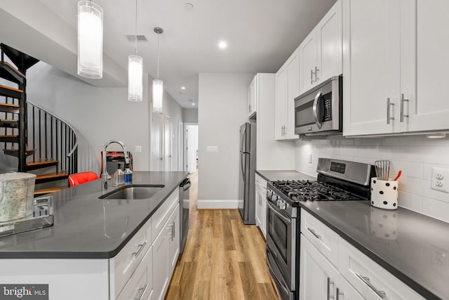 2221 M St NE Unit Ph1, Washington, DC 20002 - kitchen featuring appliances with stainless steel finishes, a sink, dark countertops, recessed lighting, and light wood-style flooring