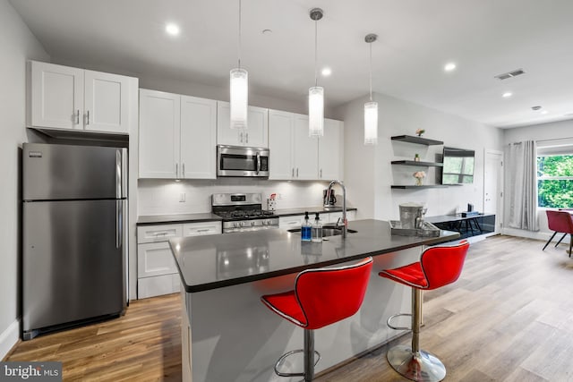 2221 M St NE Unit Ph1, Washington, DC 20002 - kitchen featuring appliances with stainless steel finishes, a sink, dark countertops, light wood finished floors, and recessed lighting