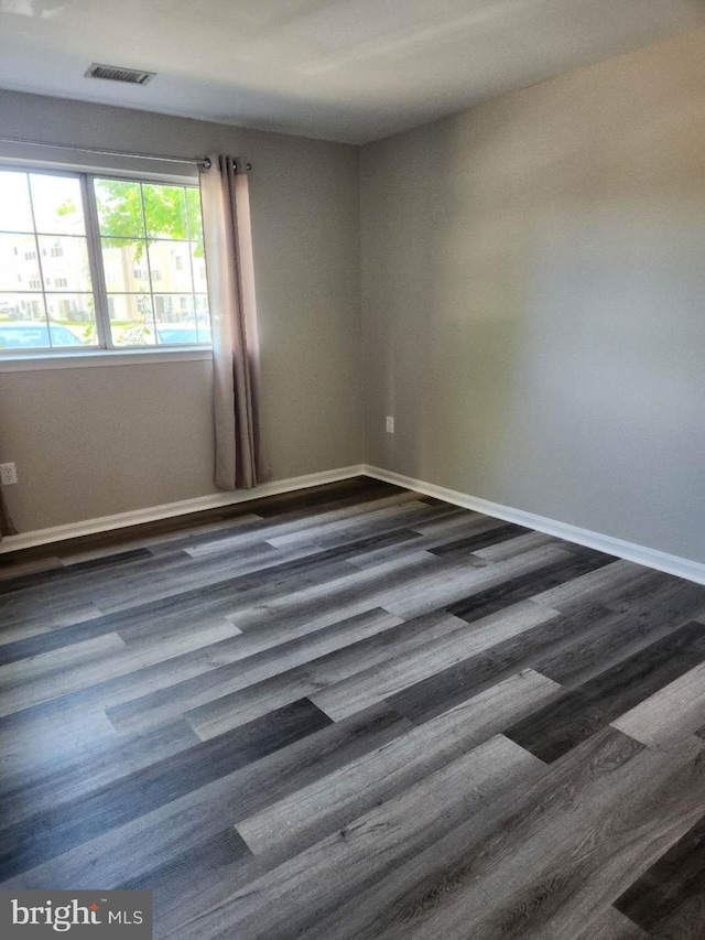 1120 Huntmaster Ter NE Unit 101, Leesburg, VA 20176 - spare room with dark wood-type flooring and baseboards