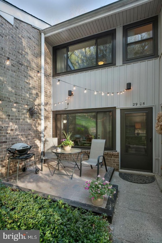 2905 Monterey Ct, Springfield, PA 19064 - view of exterior entry featuring a patio, brick siding, and board and batten siding