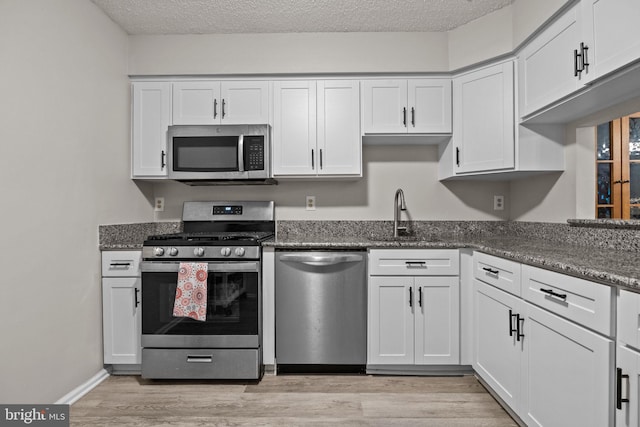 74 Haverford Ct, Hillsborough, NJ 08844 - kitchen featuring stainless steel appliances, white cabinetry, light wood finished floors, and a textured ceiling