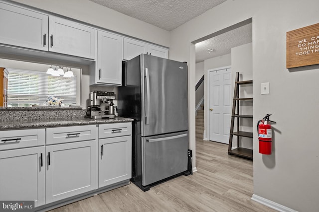 74 Haverford Ct, Hillsborough, NJ 08844 - kitchen with freestanding refrigerator, a textured ceiling, light wood-style floors, baseboards, and white cabinets