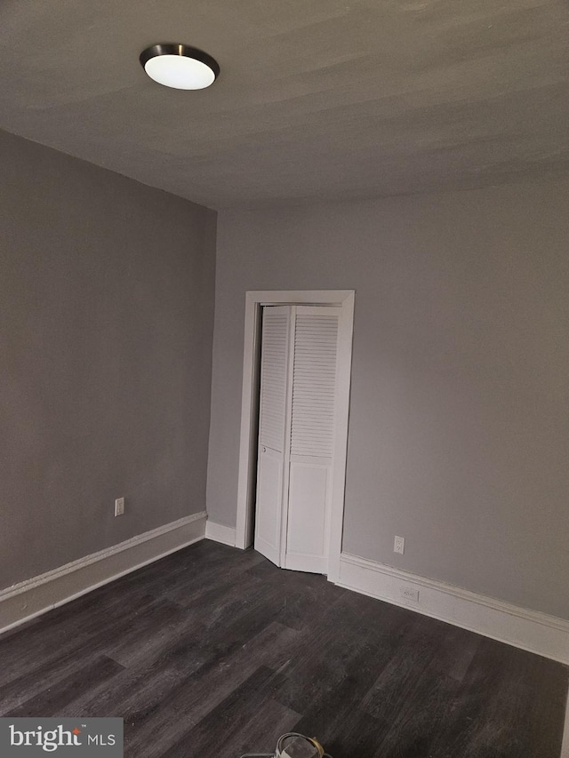 2549 N 29th St, Philadelphia, PA 19132 - unfurnished bedroom with dark wood-style floors, baseboards, and a closet