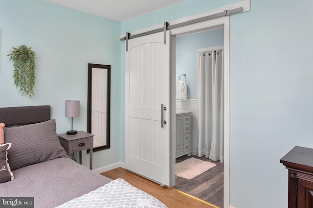 2 Gloucester Ct, Bordentown, NJ 08505 - bedroom with wood finished floors, a barn door, and baseboards