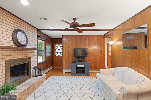 1906 Parkvue Rd, Fallston, MD 21047 - living room with light wood-style floors, wooden walls, a ceiling fan, baseboard heating, and a brick fireplace
