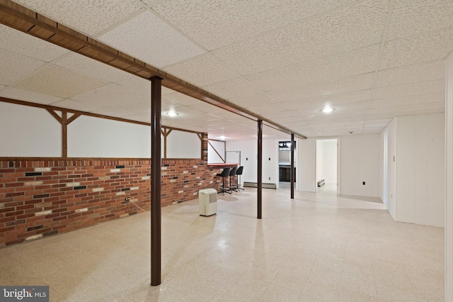 1906 Parkvue Rd, Fallston, MD 21047 - basement with tile patterned floors, brick wall, a drop ceiling, and a baseboard radiator