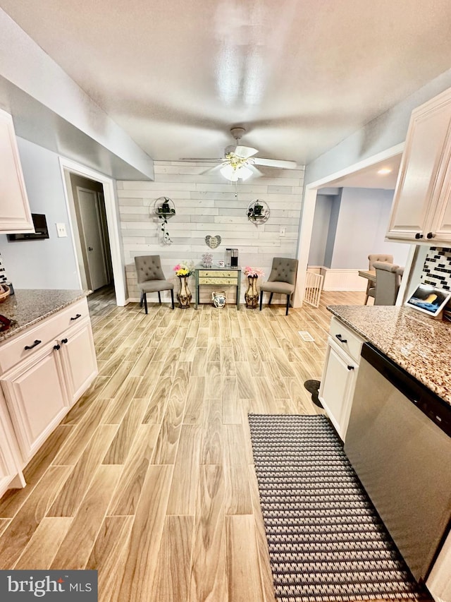 12403 Rambling Ln, Bowie, MD 20715 - kitchen featuring wood walls, a ceiling fan, light wood-style floors, dishwasher, and light stone counters