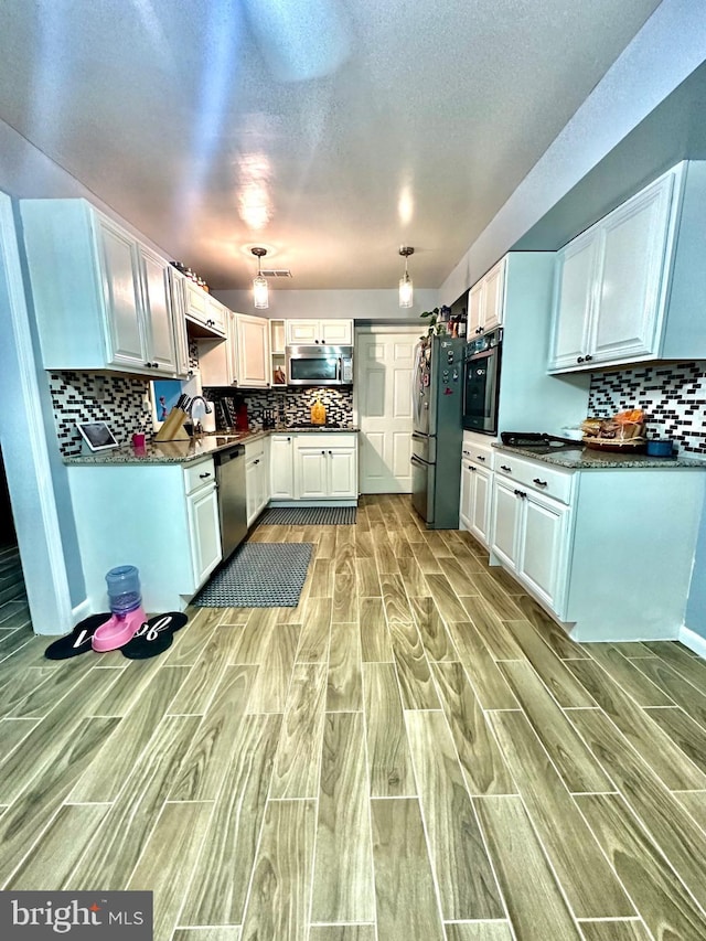 12403 Rambling Ln, Bowie, MD 20715 - kitchen with stainless steel appliances, wood tiled floors, backsplash, white cabinetry, and a textured ceiling