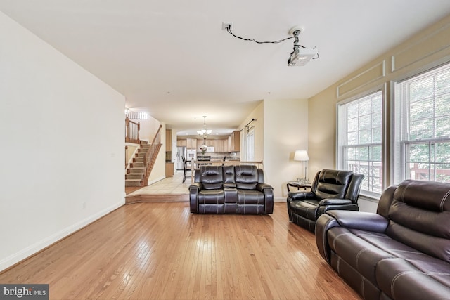 7009 Shagbark Ct, Fort Washington, MD 20744 - living area with a chandelier, light wood-style floors, baseboards, and stairway