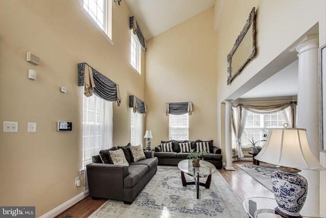 7009 Shagbark Ct, Fort Washington, MD 20744 - living area featuring a towering ceiling, wood finished floors, plenty of natural light, baseboards, and decorative columns