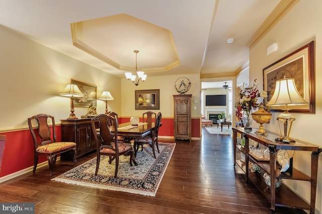 23412 Berkeley Meadows Dr, Ashburn, VA 20148 - dining room featuring dark wood-type flooring, ornamental molding, a tray ceiling, and baseboards