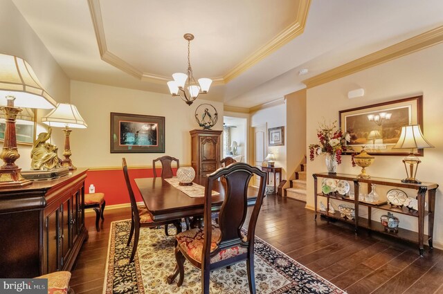23412 Berkeley Meadows Dr, Ashburn, VA 20148 - dining room featuring dark wood finished floors, a chandelier, ornamental molding, a raised ceiling, and baseboards