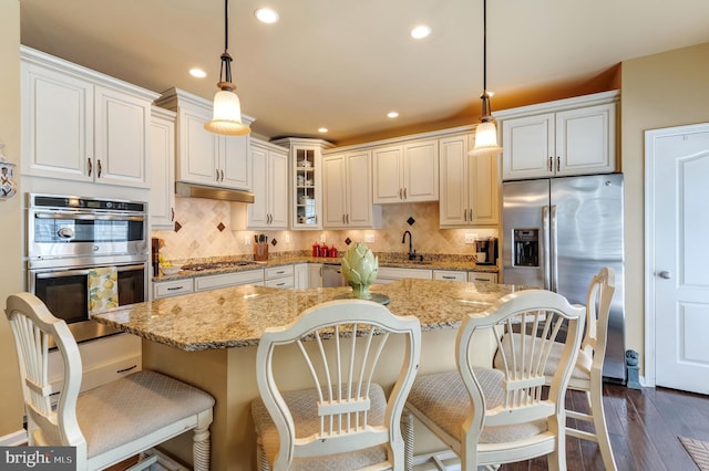 23412 Berkeley Meadows Dr, Ashburn, VA 20148 - kitchen featuring stainless steel appliances, under cabinet range hood, dark wood-type flooring, glass insert cabinets, and decorative backsplash