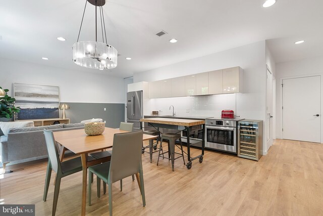 57 N St NW Unit 134, Washington, DC 20001 - dining area featuring wine cooler, bar with sink, recessed lighting, light wood finished floors, and a chandelier