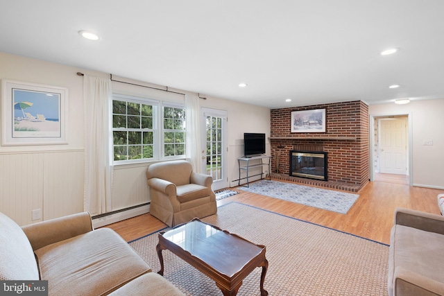 10 Old Orchard Ln, Chadds Ford, PA 19317 - living room featuring a baseboard radiator, wood finished floors, a brick fireplace, a wainscoted wall, and recessed lighting