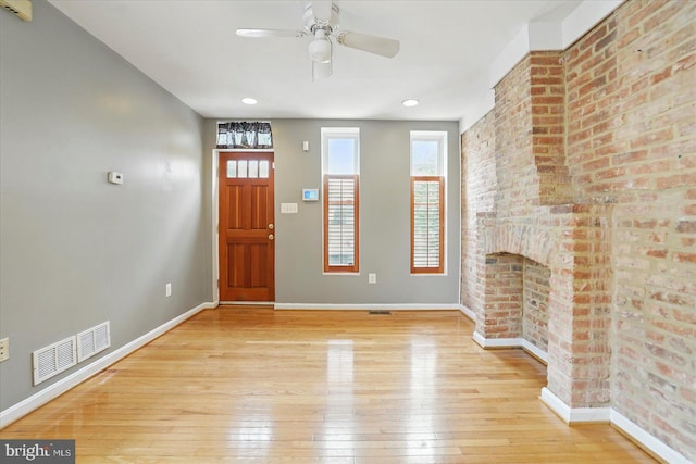 1225 W Cross St, Baltimore, MD 21230 - entryway with light wood-style floors, baseboards, ceiling fan, and a brick fireplace