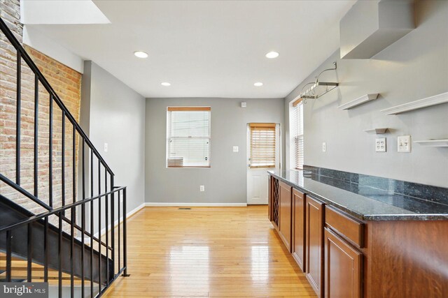 1225 W Cross St, Baltimore, MD 21230 - kitchen with light wood-type flooring, baseboards, dark stone counters, recessed lighting, and brown cabinets