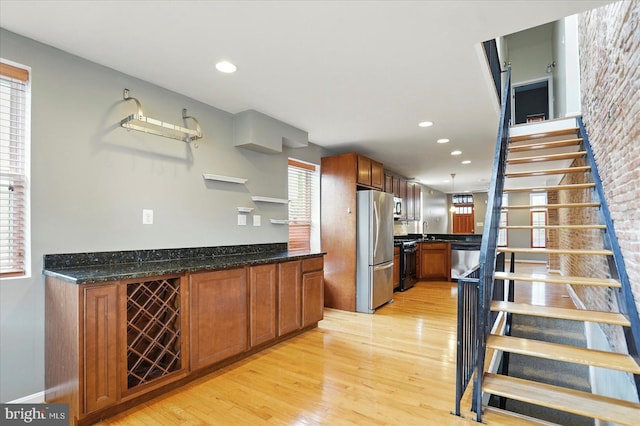 1225 W Cross St, Baltimore, MD 21230 - kitchen with freestanding refrigerator, black range with gas stovetop, light wood-style flooring, brown cabinetry, and recessed lighting