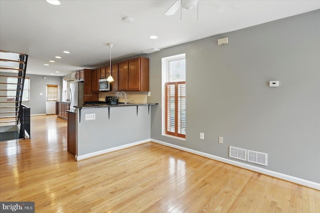 1225 W Cross St, Baltimore, MD 21230 - kitchen featuring stainless steel appliances, baseboards, a sink, a peninsula, and ceiling fan