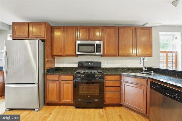 1225 W Cross St, Baltimore, MD 21230 - kitchen featuring stainless steel appliances, a sink, light wood finished floors, and brown cabinets