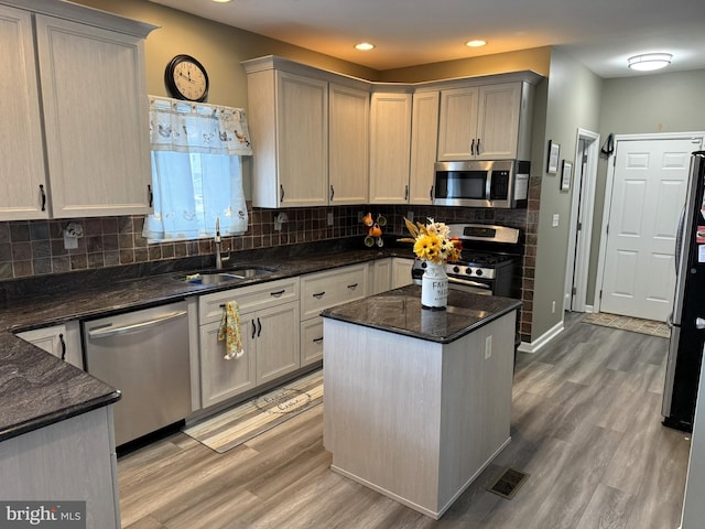 128 E Delaware Dr, Little Egg Harbor Twp, NJ 08087 - kitchen featuring appliances with stainless steel finishes, a sink, light wood finished floors, tasteful backsplash, and a center island