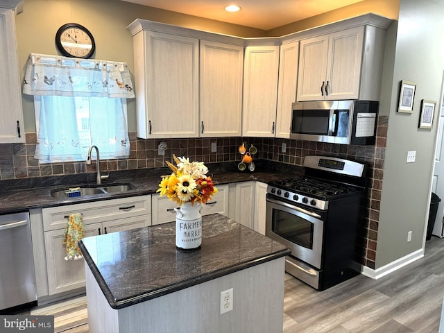 128 E Delaware Dr, Little Egg Harbor Twp, NJ 08087 - kitchen featuring appliances with stainless steel finishes, a sink, light wood-style floors, backsplash, and a kitchen island