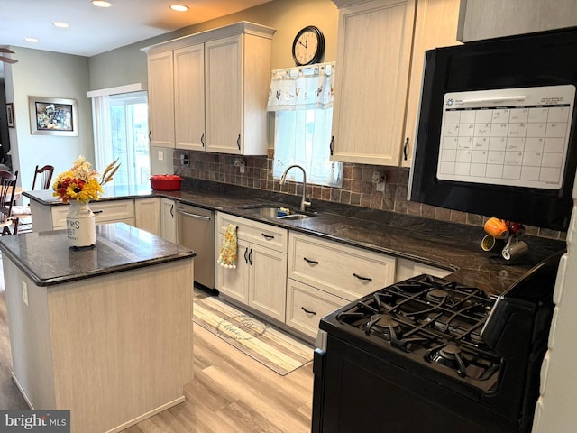 128 E Delaware Dr, Little Egg Harbor Twp, NJ 08087 - kitchen with stainless steel dishwasher, a sink, black range with gas stovetop, light wood-style flooring, and backsplash