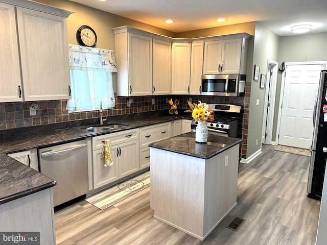 128 E Delaware Dr, Little Egg Harbor Twp, NJ 08087 - kitchen featuring appliances with stainless steel finishes, a sink, light wood finished floors, backsplash, and a center island