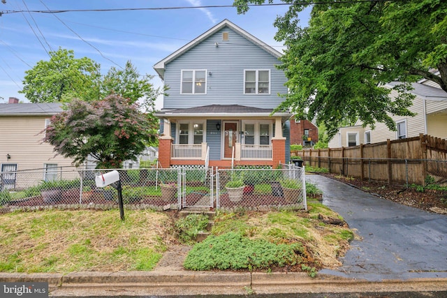 4311 Quinn St, Capitol Heights, MD 20743 - view of front of house with a porch, a fenced front yard, a gate, and brick siding