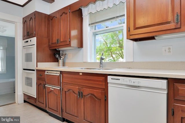 604 Market St, Pocomoke City, MD 21851 - kitchen with white appliances, a sink, light countertops, and brown cabinetry