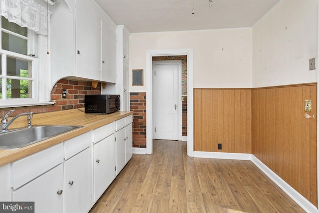 10 Pershing Ave, Ewing, NJ 08618 - kitchen with a sink, black microwave, white cabinets, a wainscoted wall, and light wood-style floors