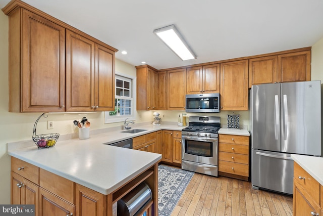 9300 Olivia Pl, Burke, VA 22015 - kitchen with stainless steel appliances, a sink, brown cabinets, light countertops, and light wood-type flooring