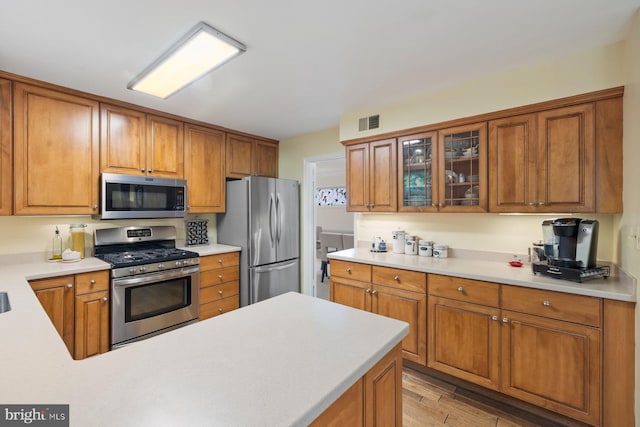 9300 Olivia Pl, Burke, VA 22015 - kitchen with stainless steel appliances, light countertops, and brown cabinetry