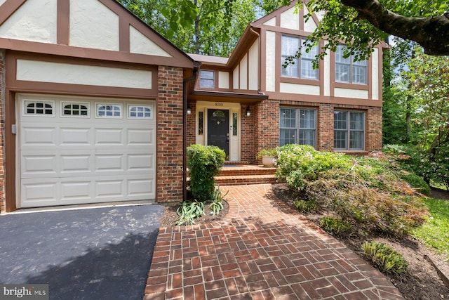 9300 Olivia Pl, Burke, VA 22015 - tudor home with stucco siding, driveway, brick siding, and an attached garage