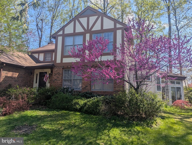 9300 Olivia Pl, Burke, VA 22015 - tudor house featuring brick siding, a front yard, and stucco siding